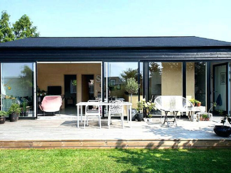 Gelijkvloerse houten woning met glazen schuifpuien en terras, geschikt als mantelzorgwoning