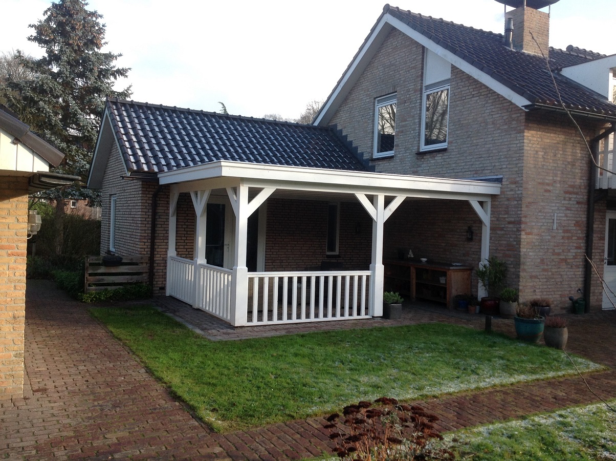Houten veranda aan huis met wit hekwerk en pannendak in Groningen