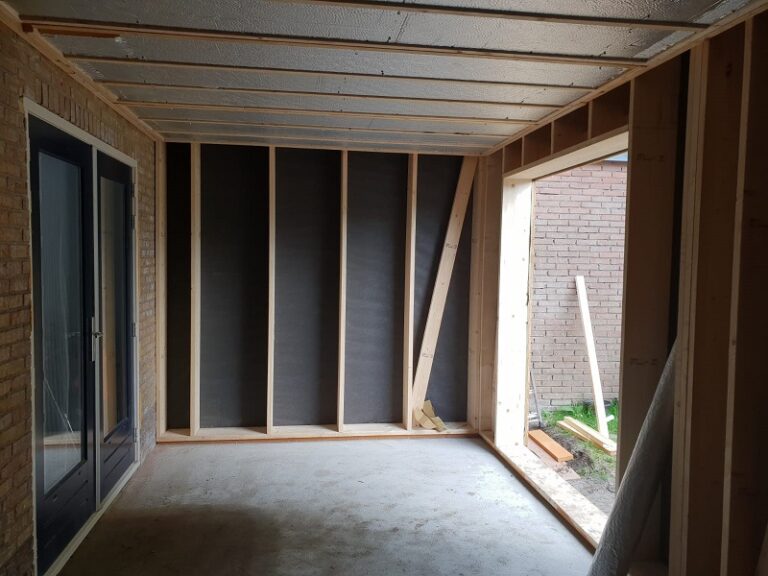 Houten wand met isolatie en folie aan de binnenkant tijdens de bouw