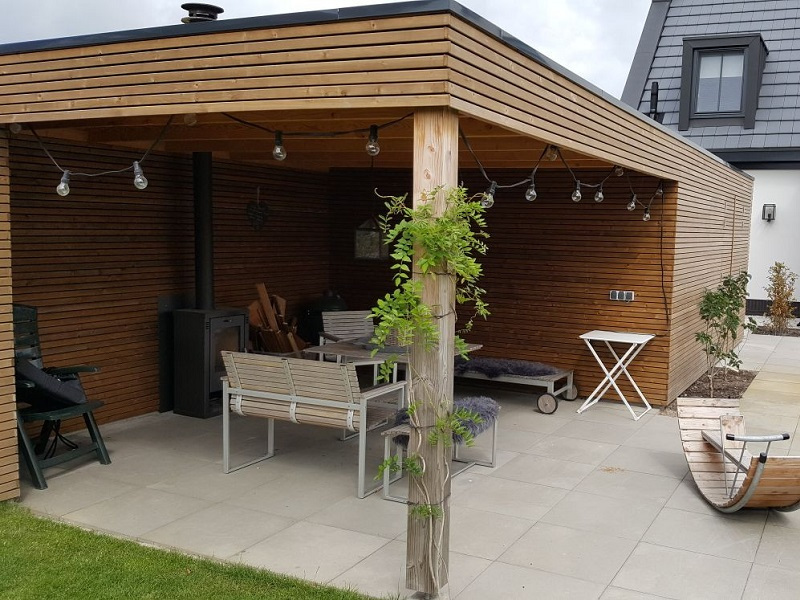 Houten tuinschuur met overkapping en loungeplek in Limmen