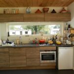 Tuinkantoor laten bouwen: interieur met keukenblok, houten plafond en grote ramen in Oudehaske