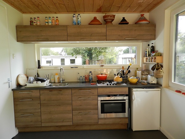 Tuinkantoor laten bouwen: interieur met keukenblok, houten plafond en grote ramen in Oudehaske